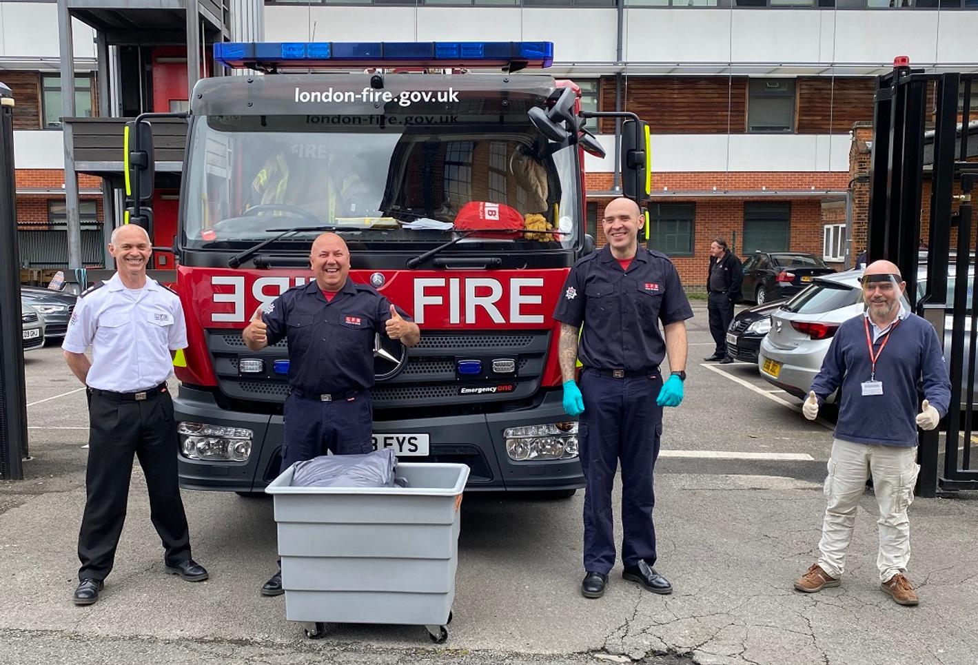Three men and an MDX staff standing next to a fire truck