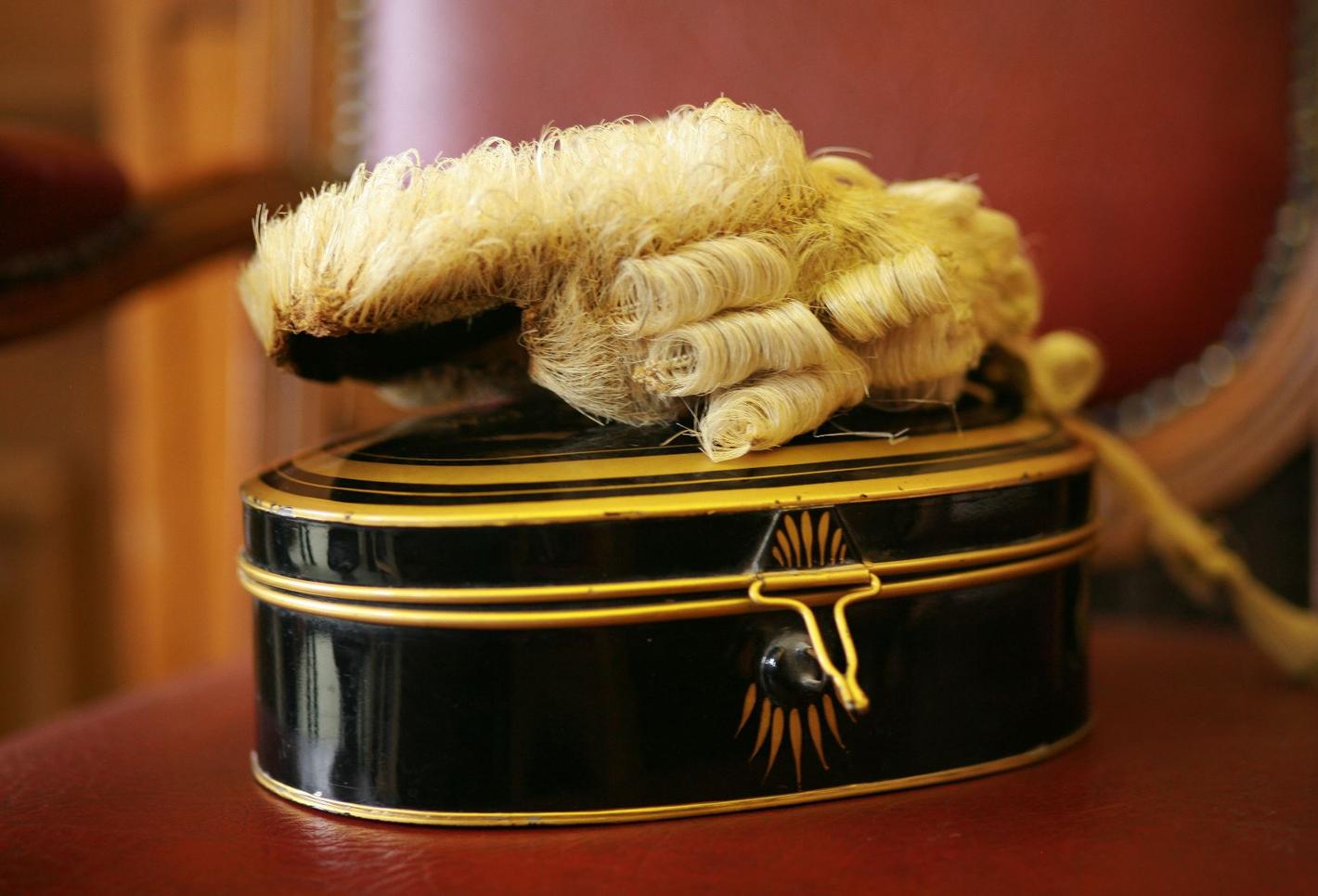 legal wig on top of black-painted polished wooden box