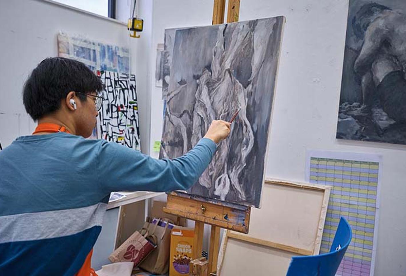 Art student painting on canvas in art studio