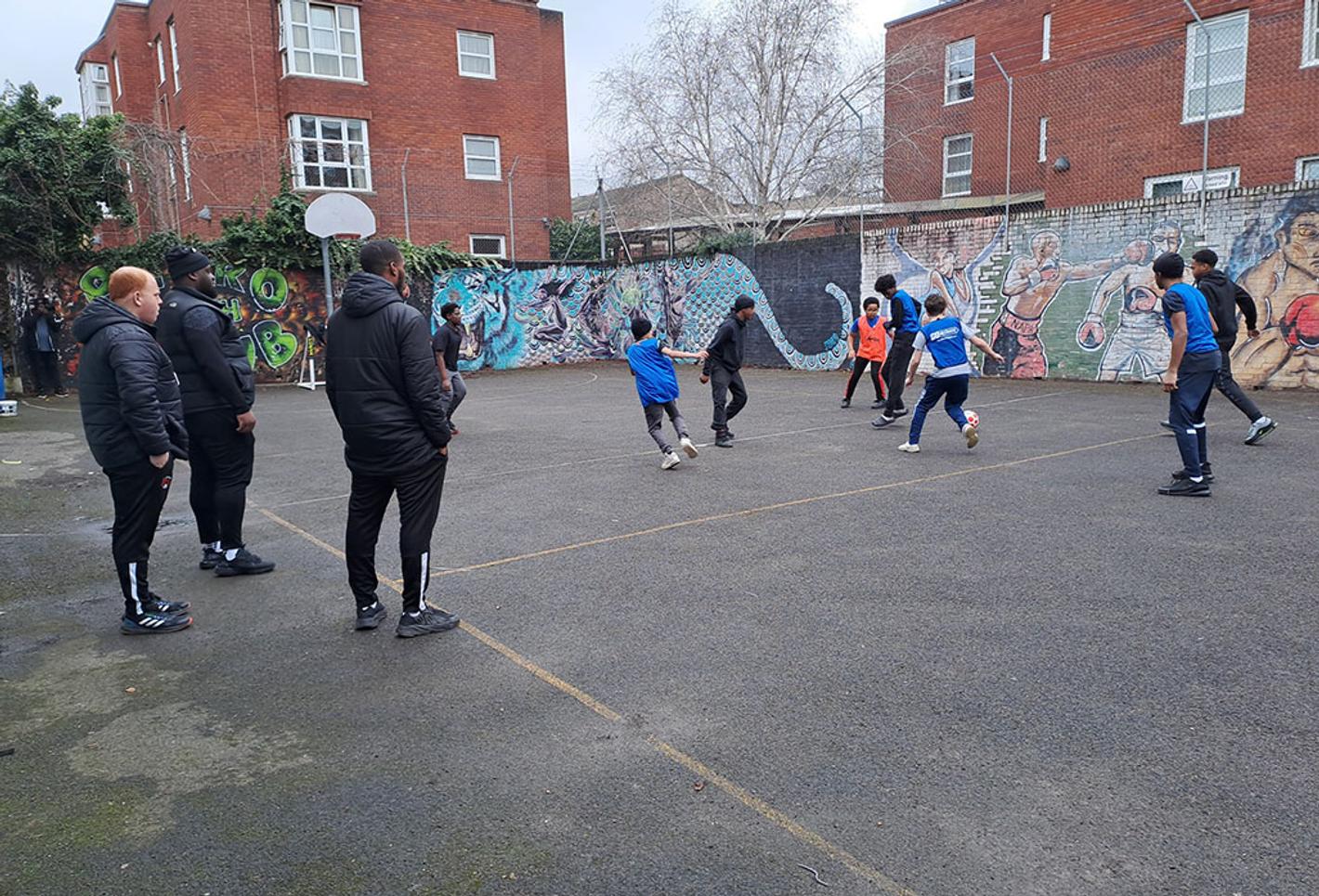 Children playing football in a court