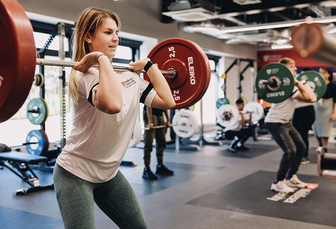 Woman lifts weight in the gym