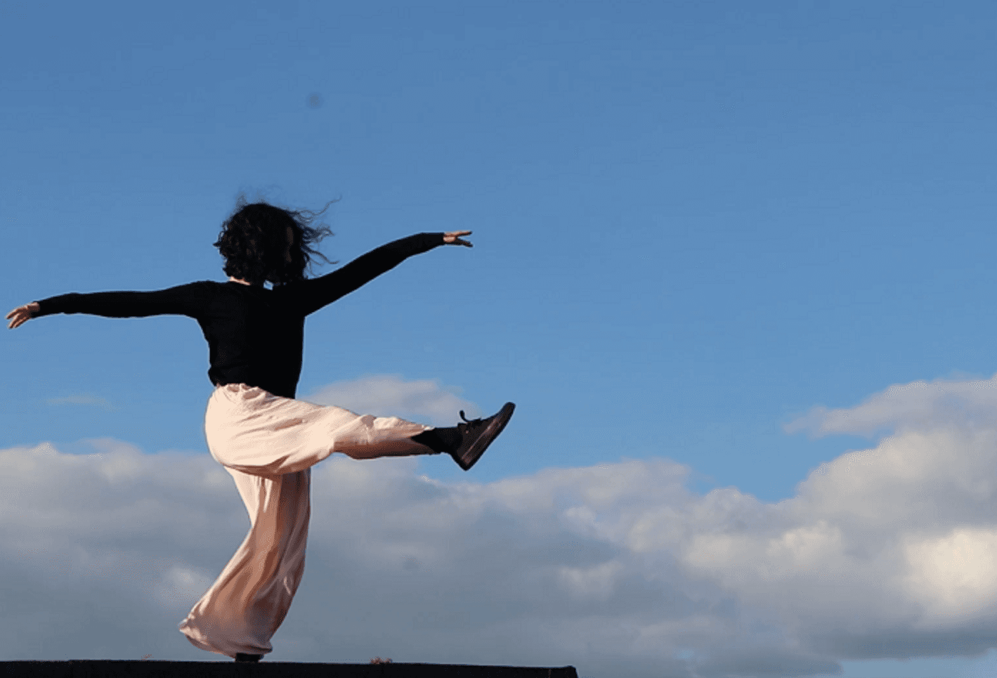Girl dancing under the blue sky