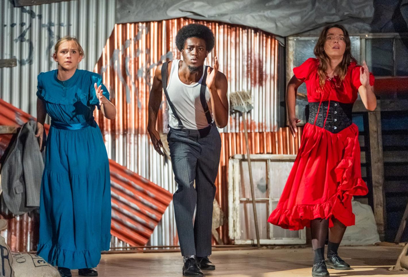 Three Middlesex students acting onstage in a live theatre production