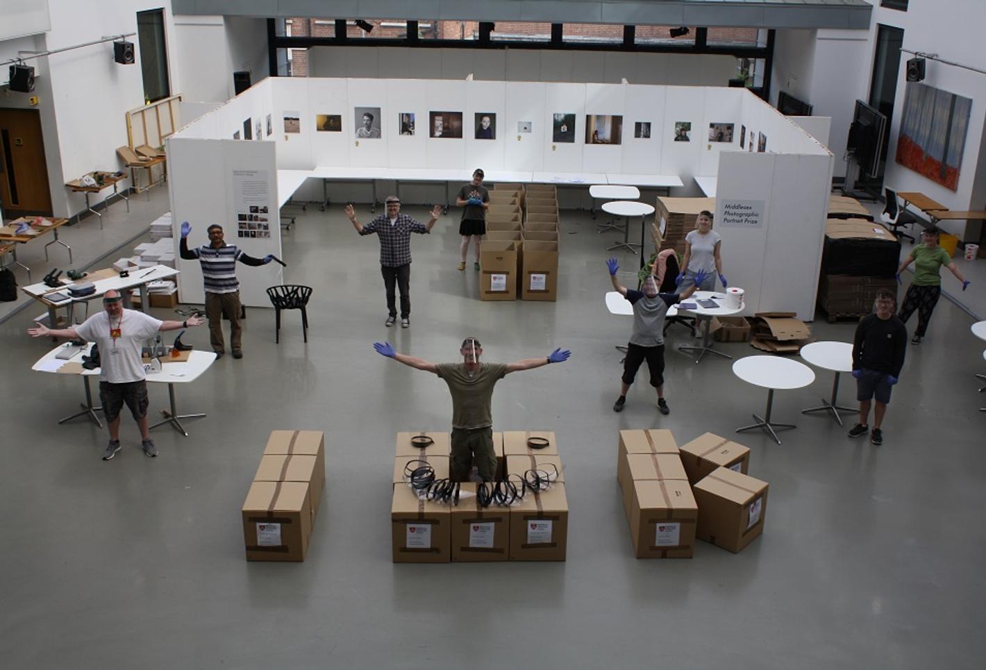 Image of people standing around boxes arranged as '10K', representing Team MDX's effort in creating 10,000 visors for the NHS in a week.