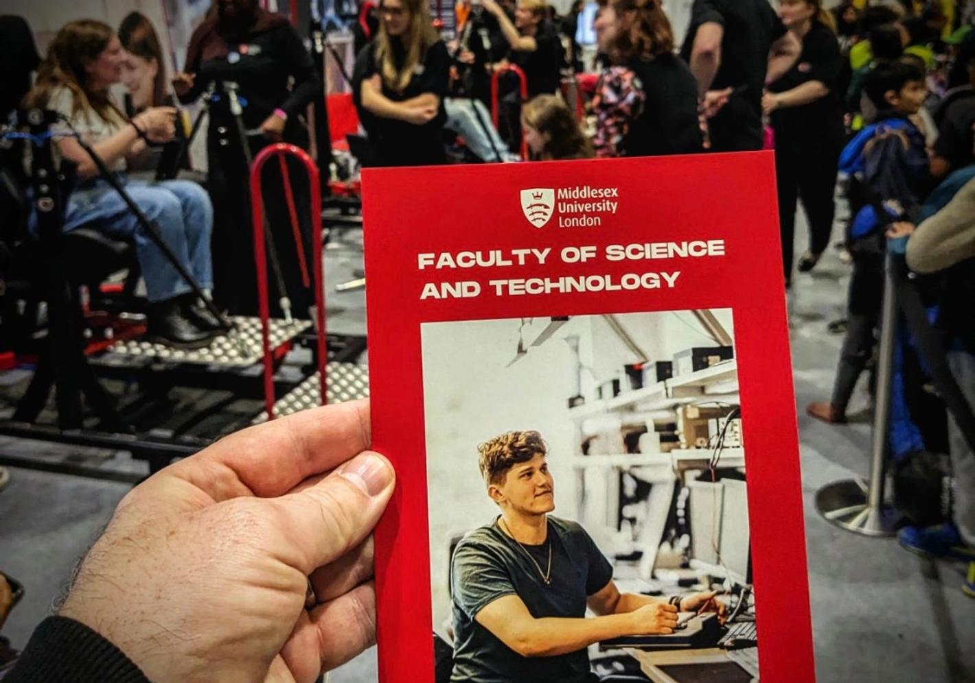 Visitor holding a faculty of science and technology event programme
