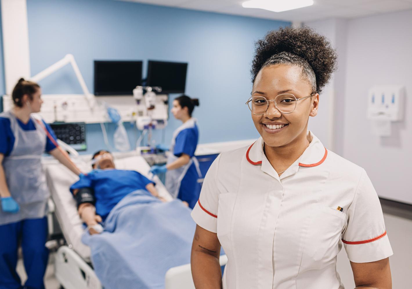 Healthcare students take part in a patient care simulation in a university clinical training environment