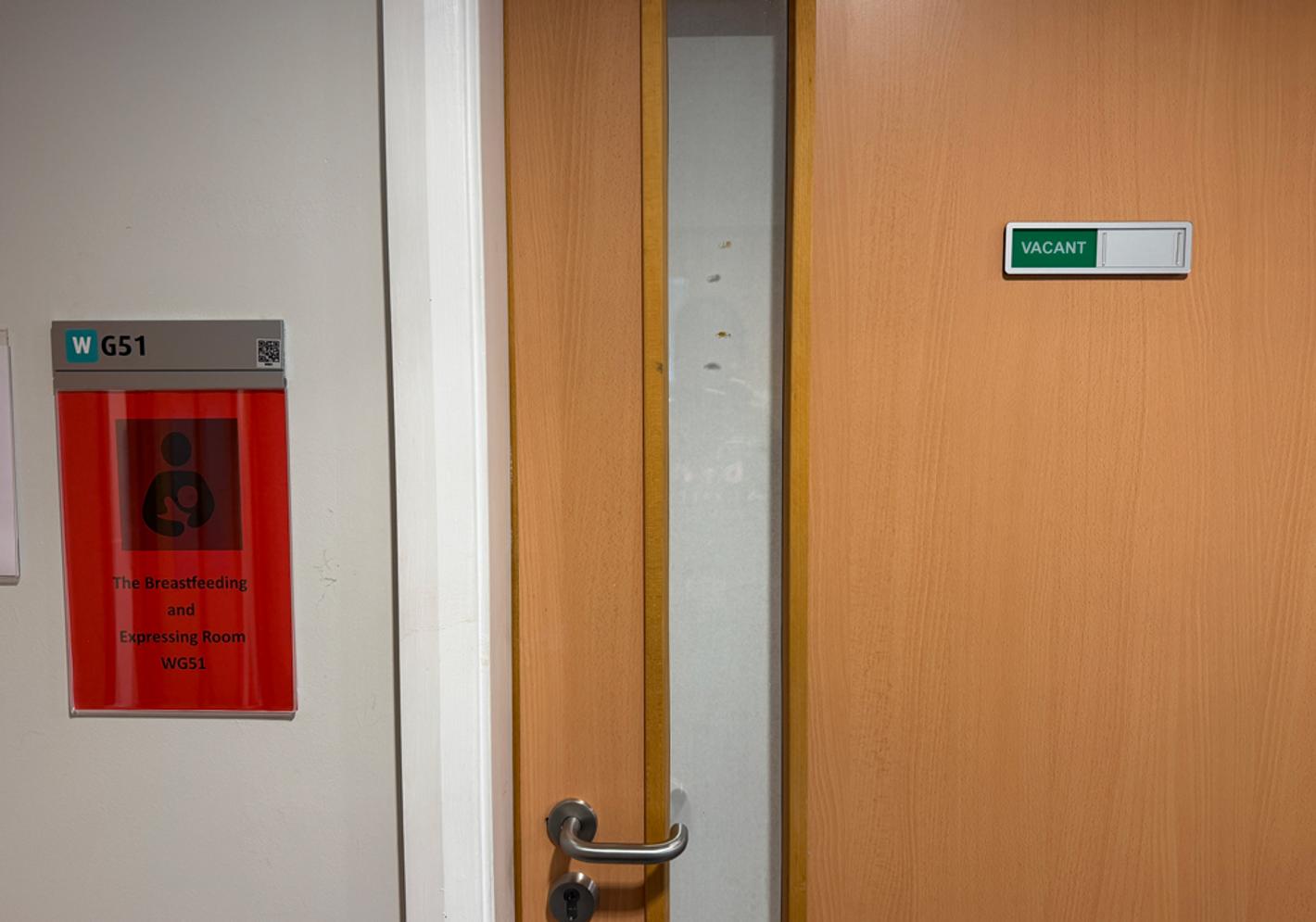 A notice on a wall next to a door of a room designated for breastfeeding