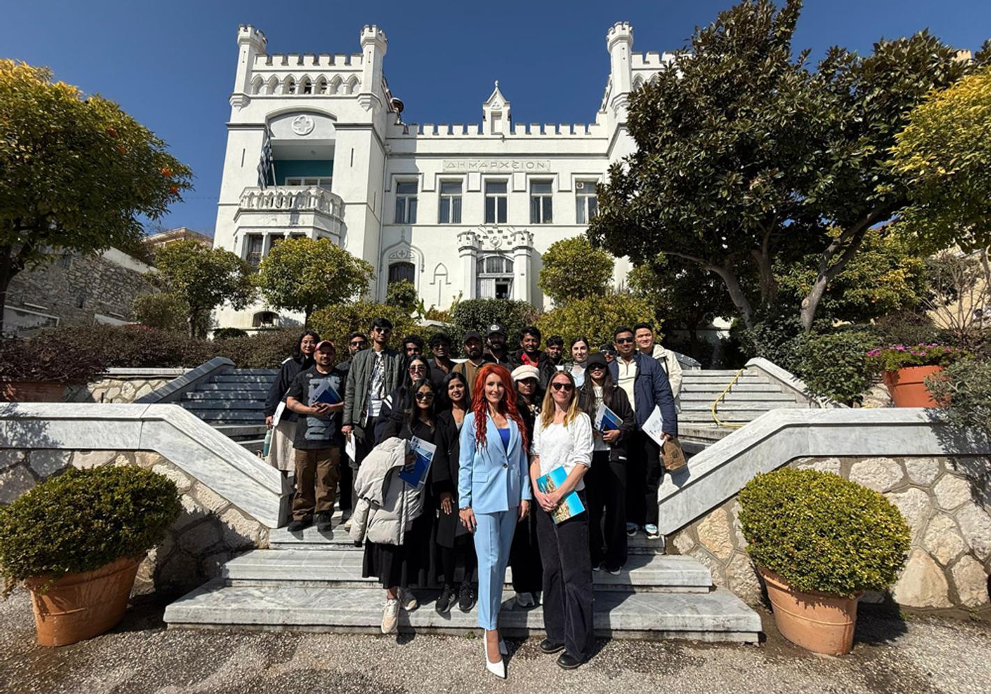 A group of people posing for a photo outside Kavala City Hall in Greece