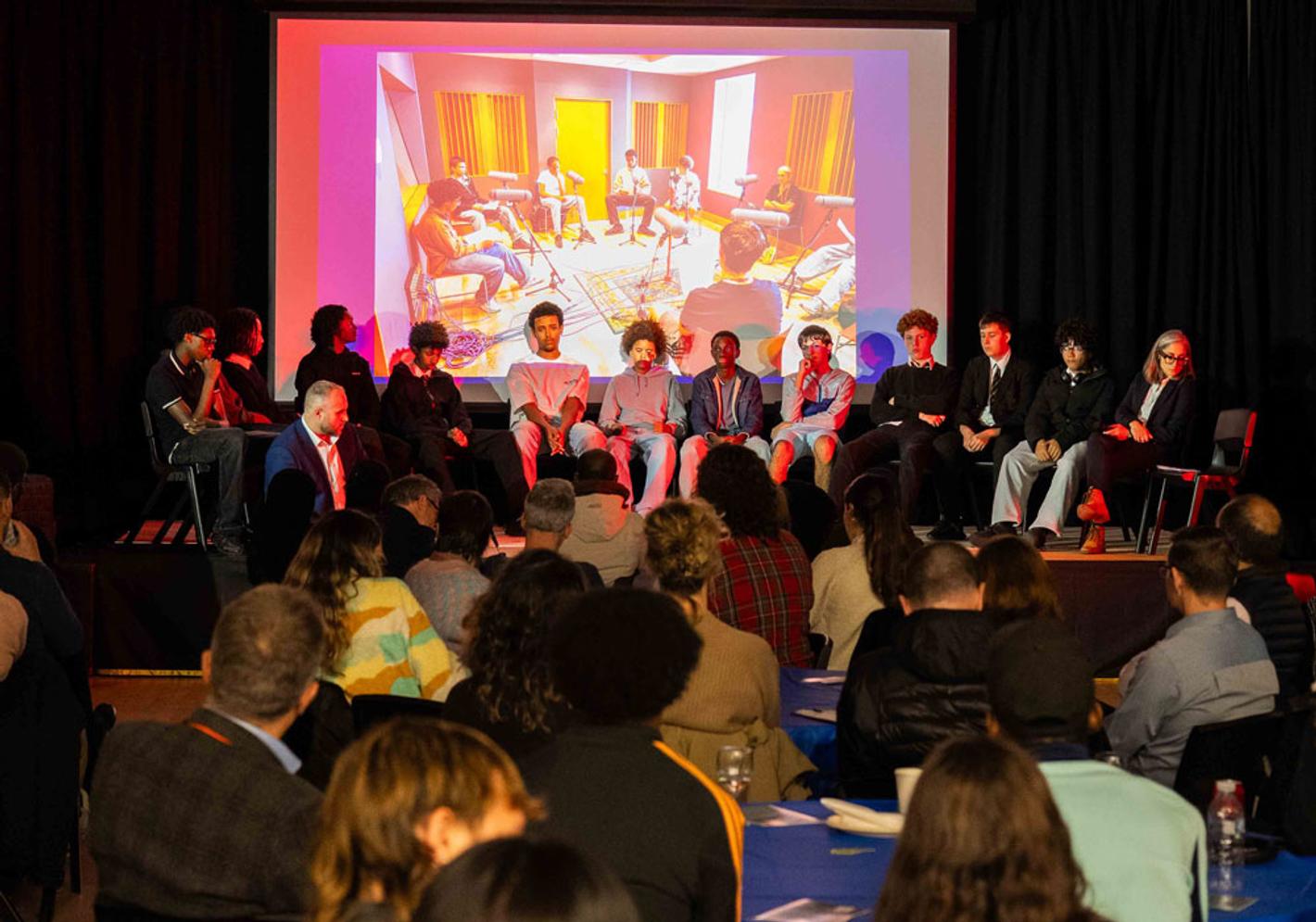 Group of boys sitting on stage during a panel discussion at From The Boys podcast launch event.