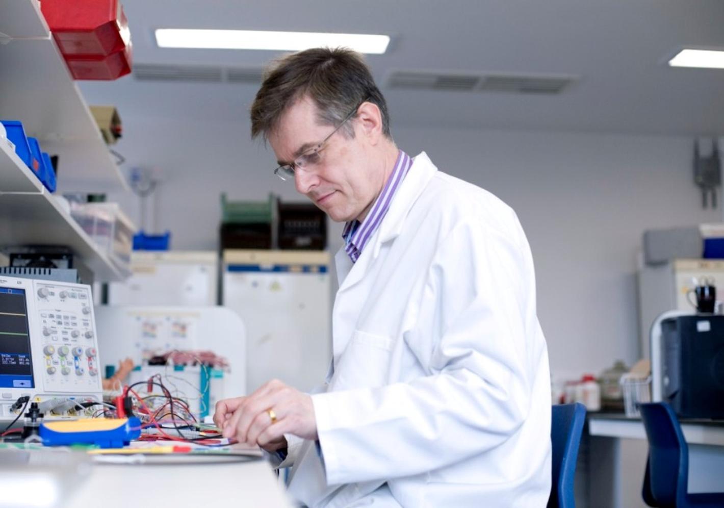 teacher in white lab coat examining something