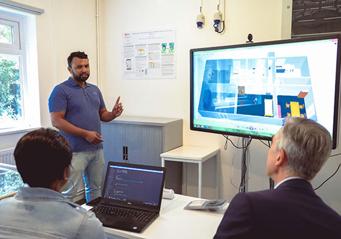 student gives presentation to teachers with screen that shows 3d model