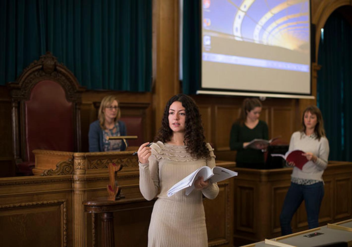 student presents in courtroom-like setting