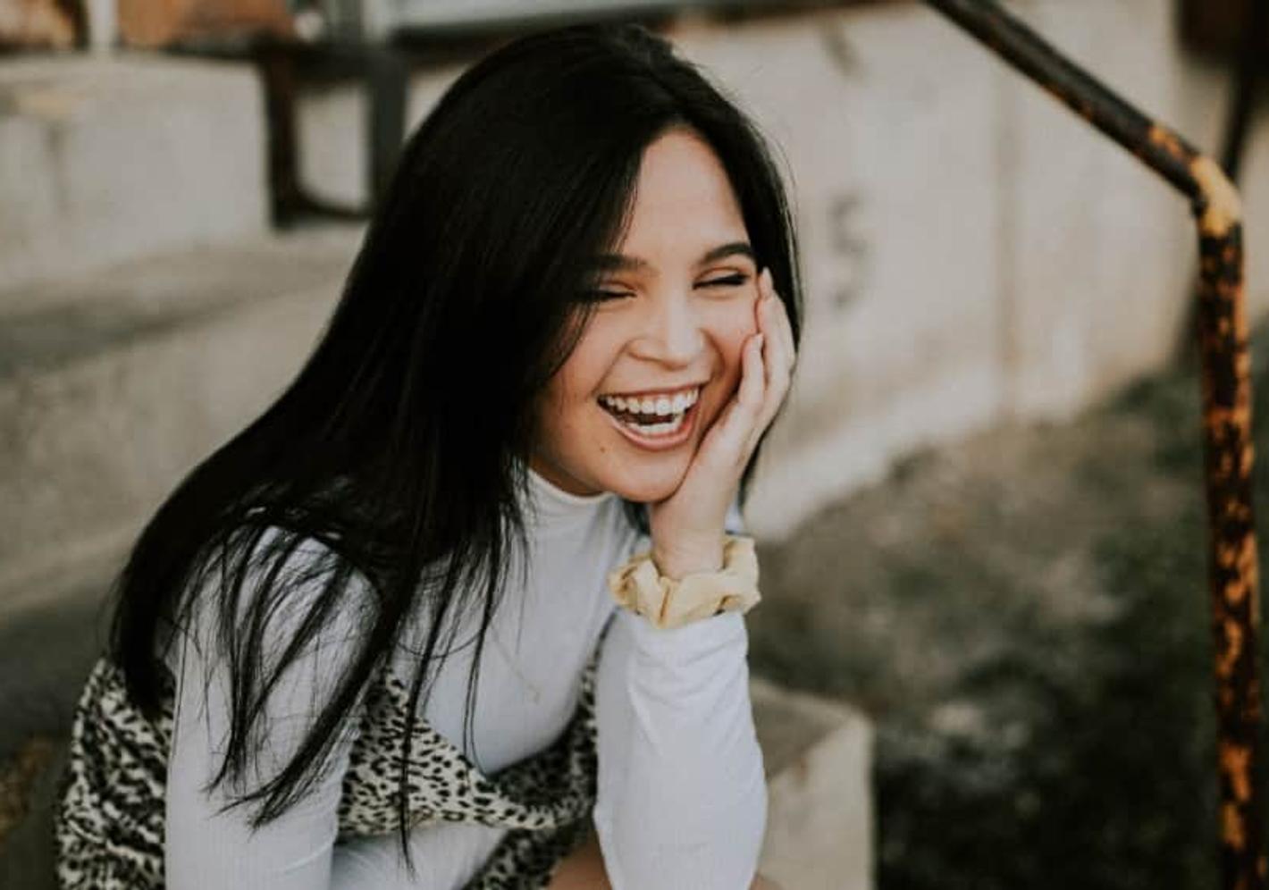 Person with long dark hair smiling