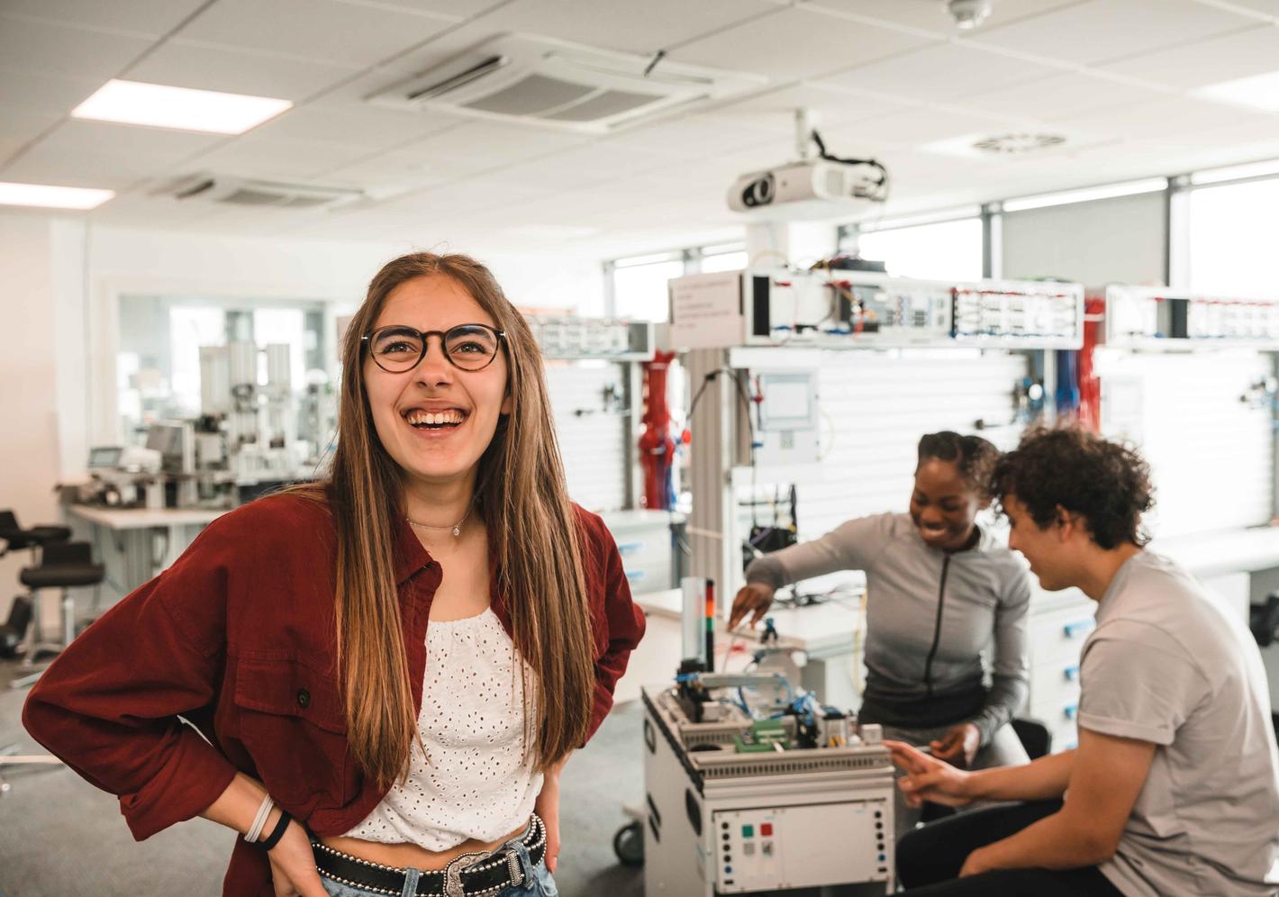 A student smiling in an engineering lab