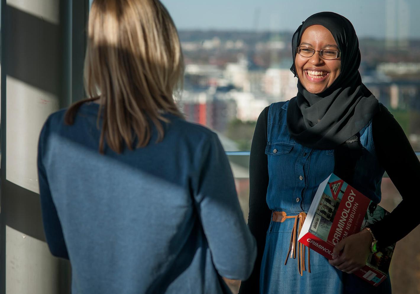 Two students chatting on campus on a sunny day