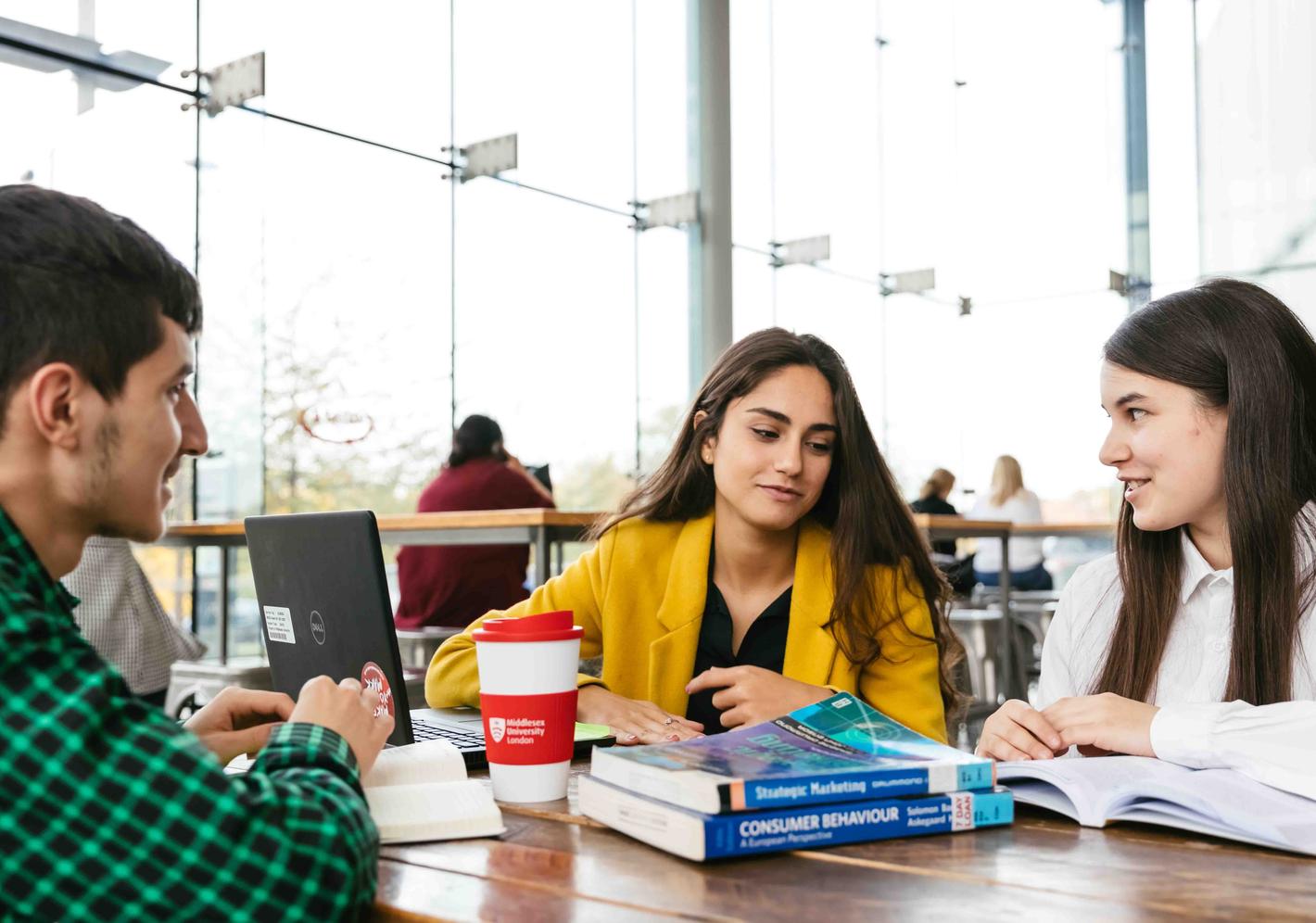 Three Business students working in a cafe