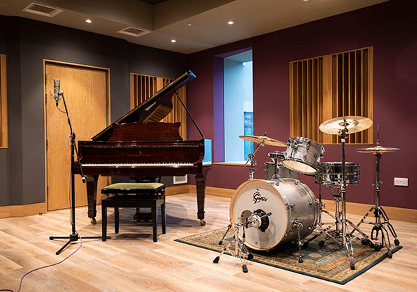 Music equipment including Piano, Mic and Drum Kit in recording studio