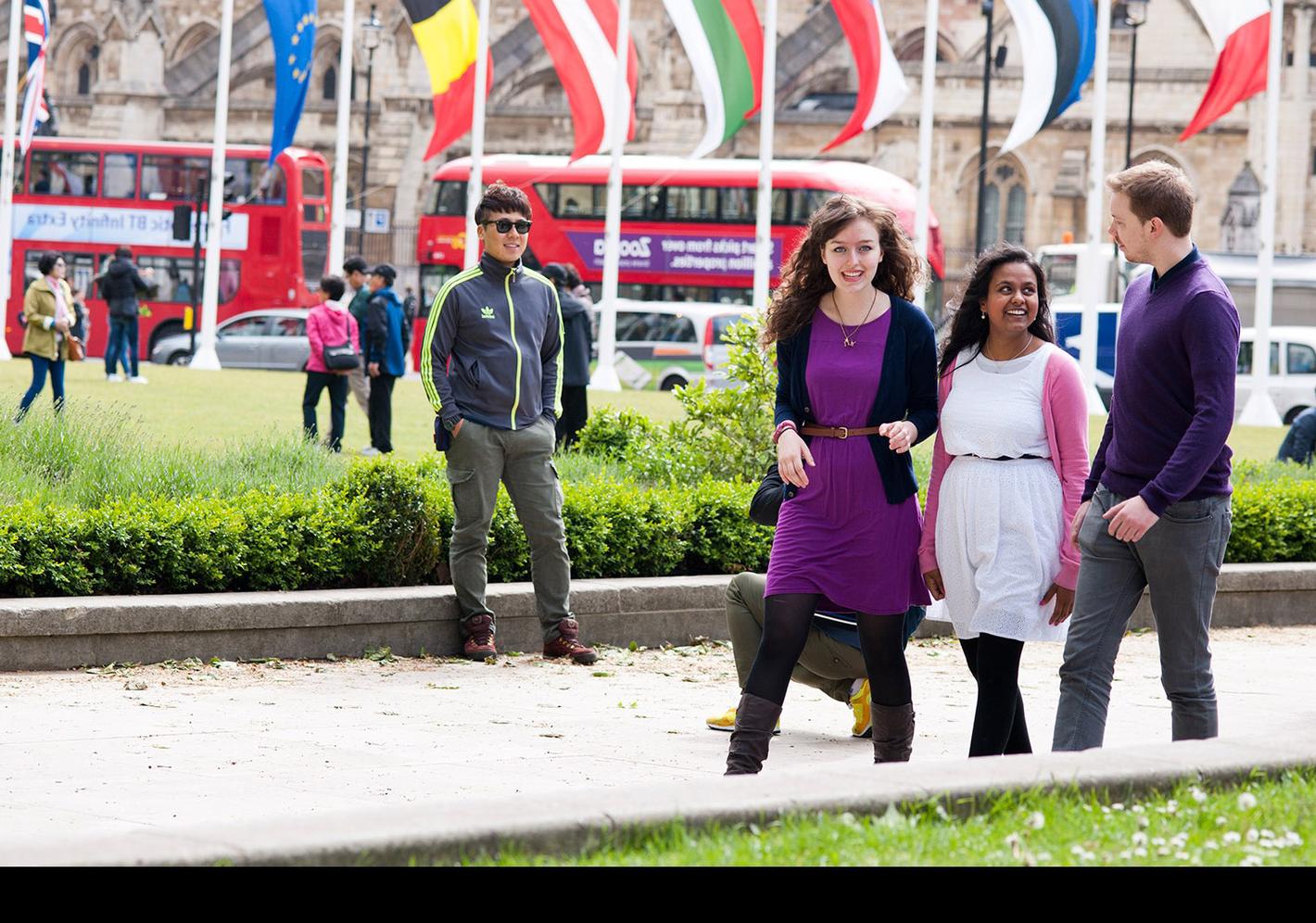 Three young people walking in a park, enjoying nature and each other's company. A perfect representation of international tourism and hospitality.