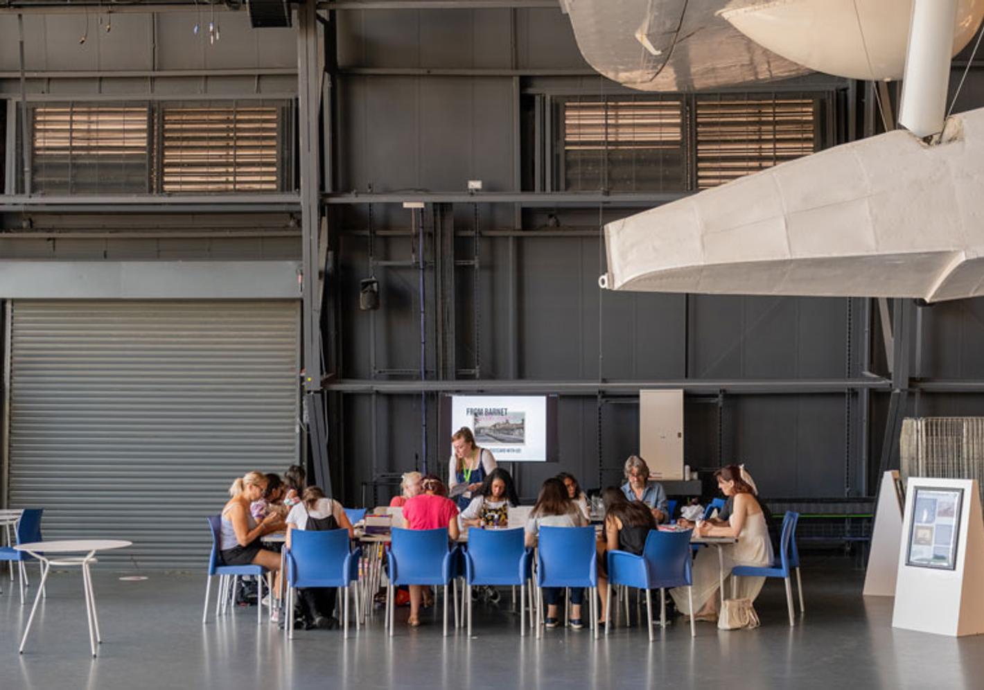 Group of students gathered around a table taking part in a creative workshop activity.