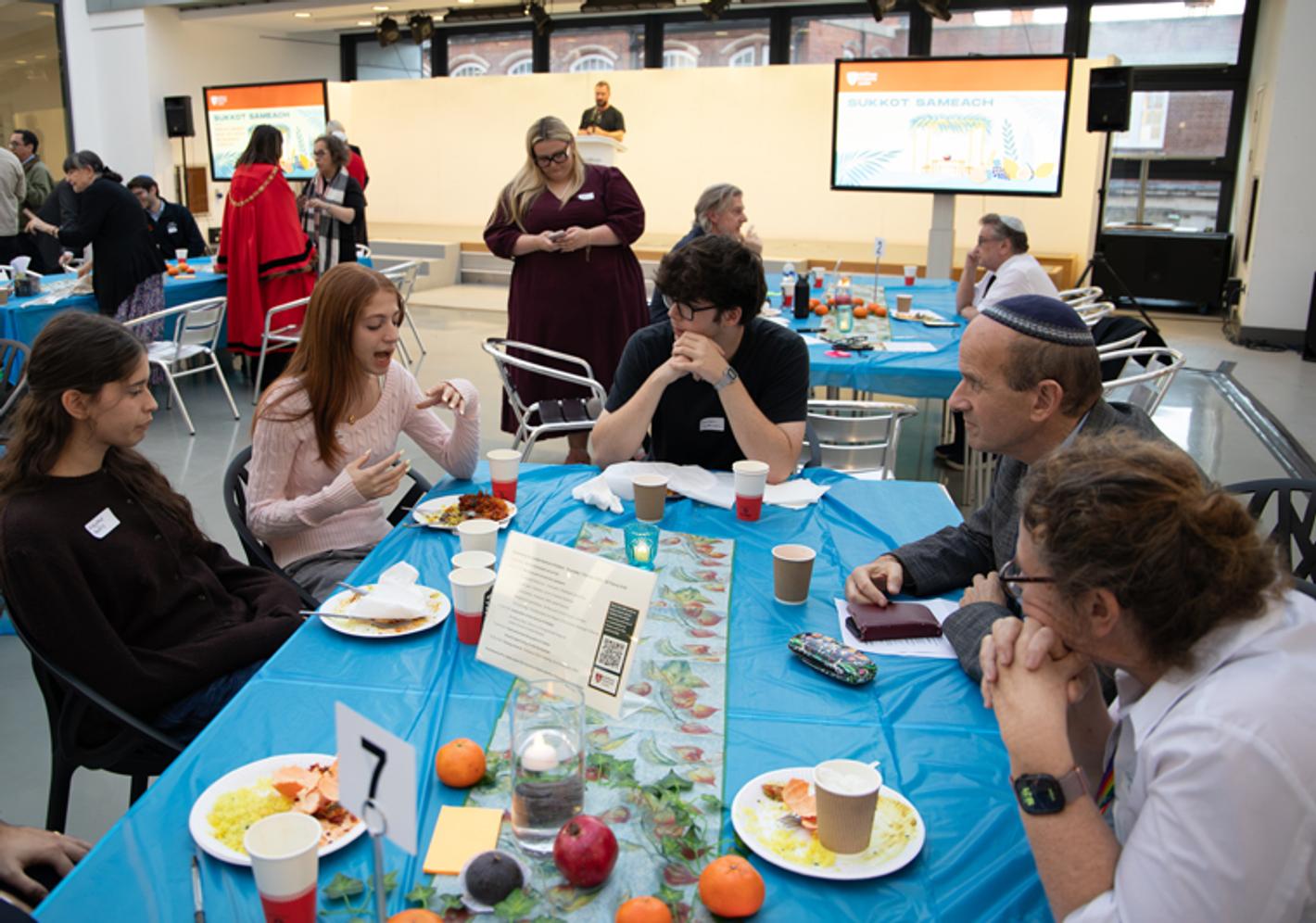 Adults around a table celebrating Sukkot