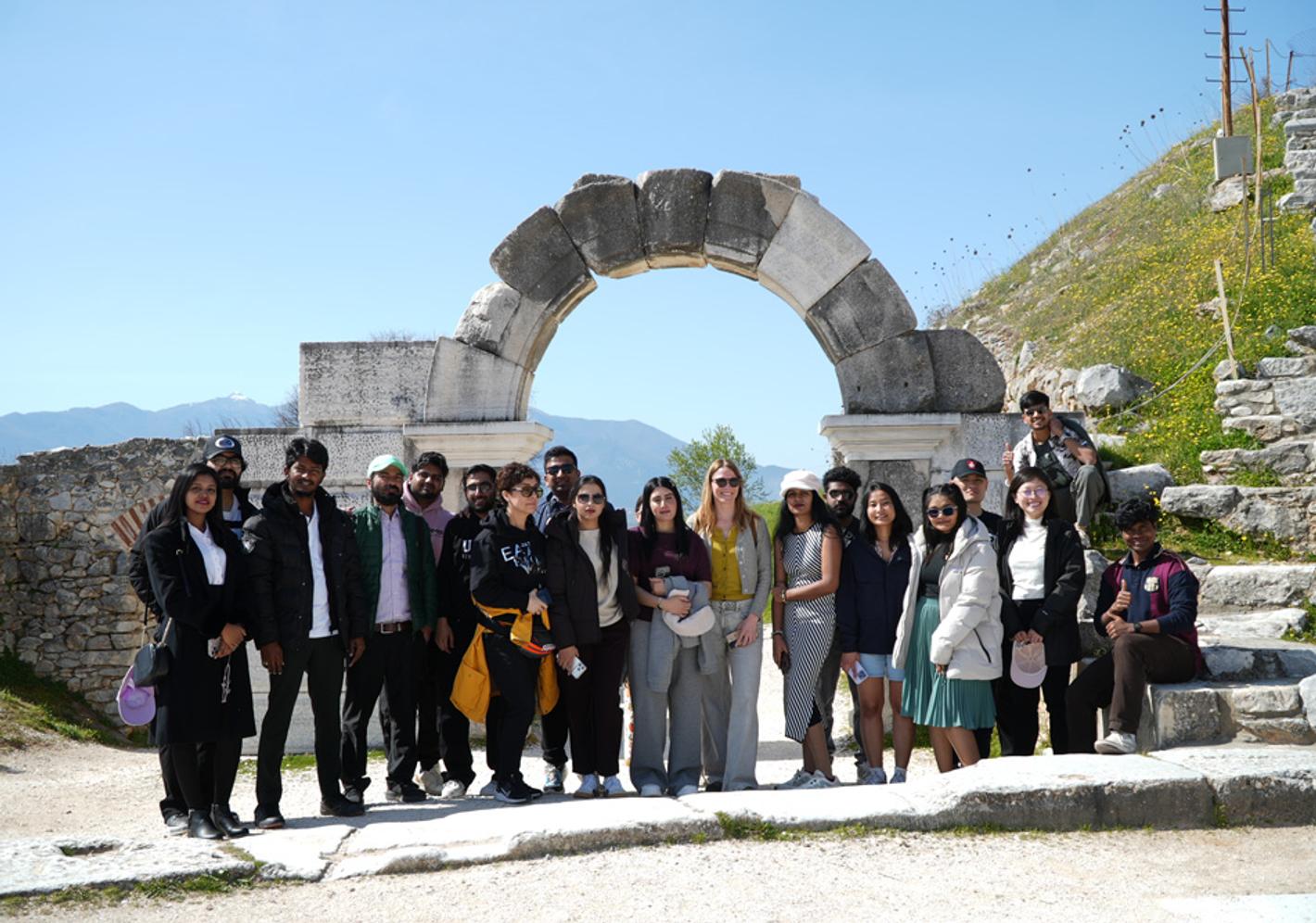 A group of people posing for a photo at the archaeological site of Philippi in Greece