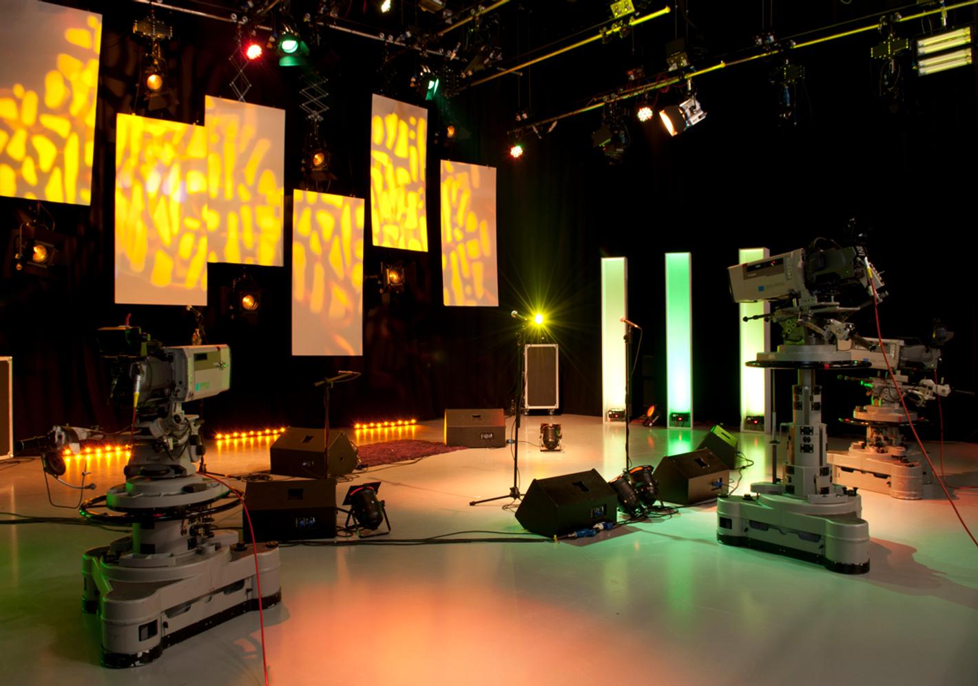 a TV studio with two large cameras and a studio backdrop