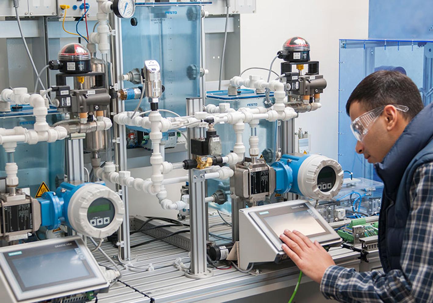A man in a factory working on a machine. Engineering Project Management.
