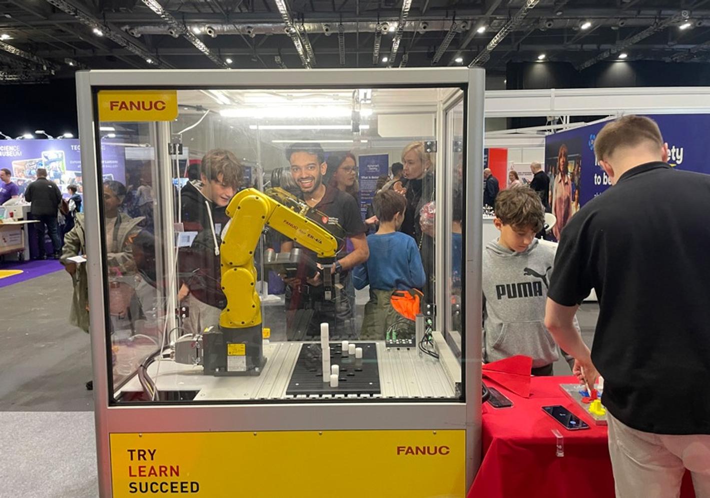 MDX's yellow FANUC industrial robot arm at New Scientist Live
