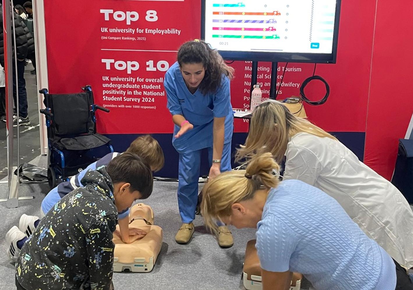 A lecturer leads a resuscitation session, with students training on body dummies
