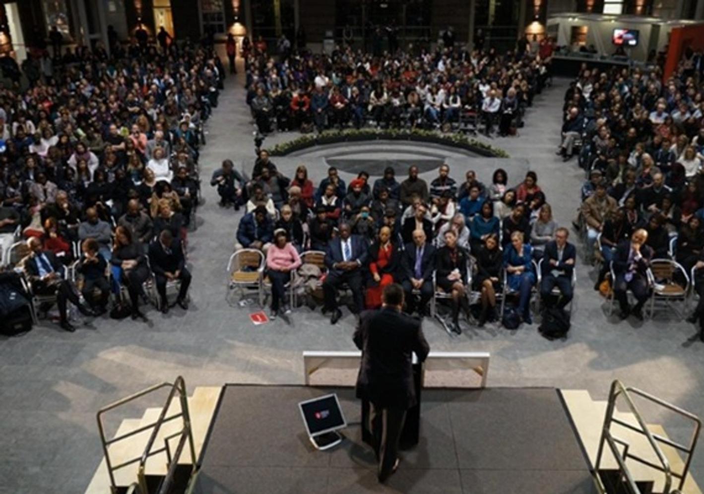 Jesse Jackson on a podium speaking to a large audience at Middlesex University London's Quad