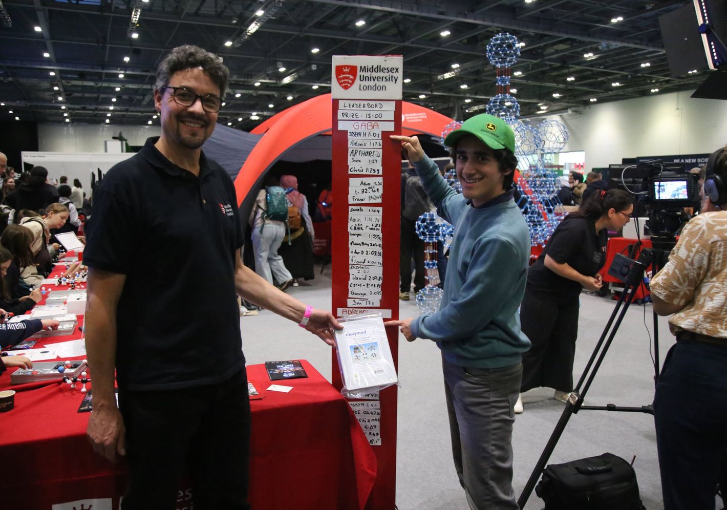 Member of staff and a student check out the leaderboard at the New Scientist event