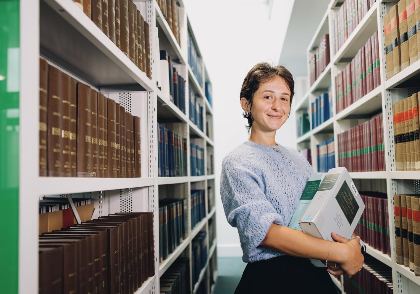 female middlesex university student in the sheppard library carrying books