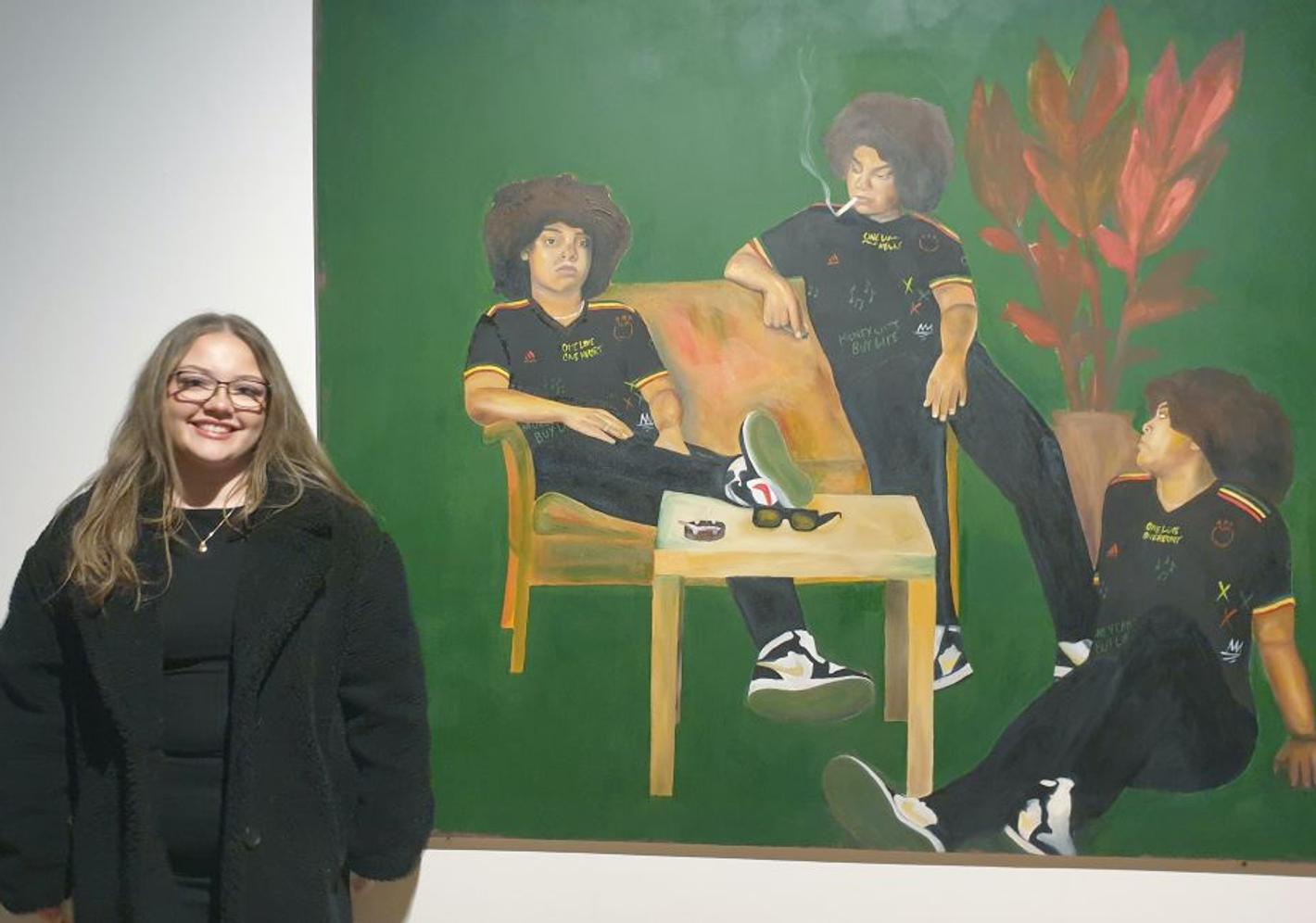 Woman shows her painting of three men