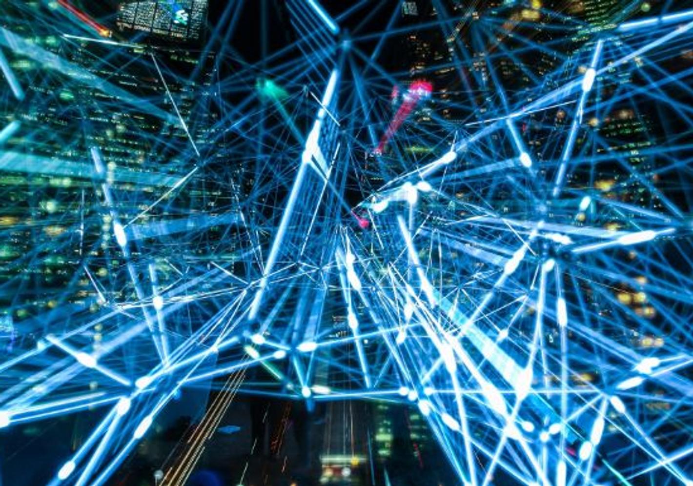 Abstract cityscape with glowing lights and intricate network of wires, showcasing the interconnectedness of urban life.