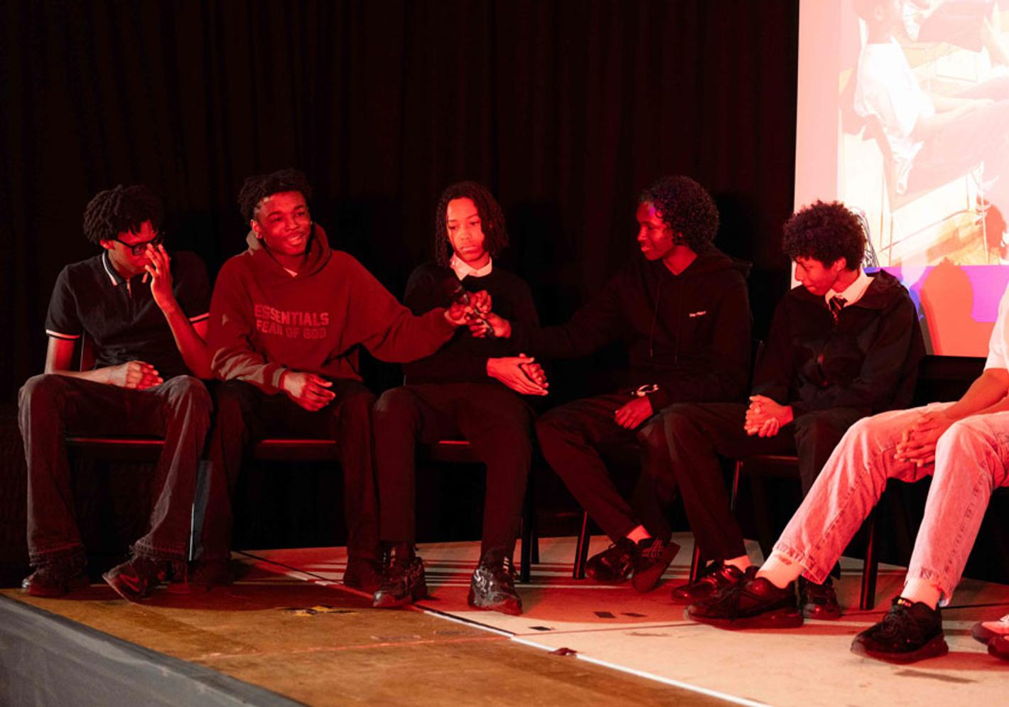 Group of pupils speaking on stage at The Boys podcast launch event.