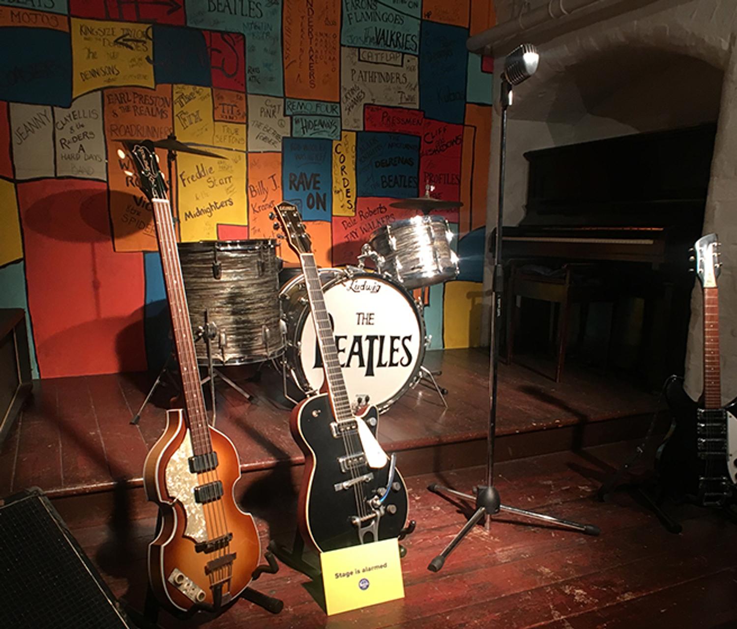 A guitar, drum, and microphone on a stage, ready for a musical performance.