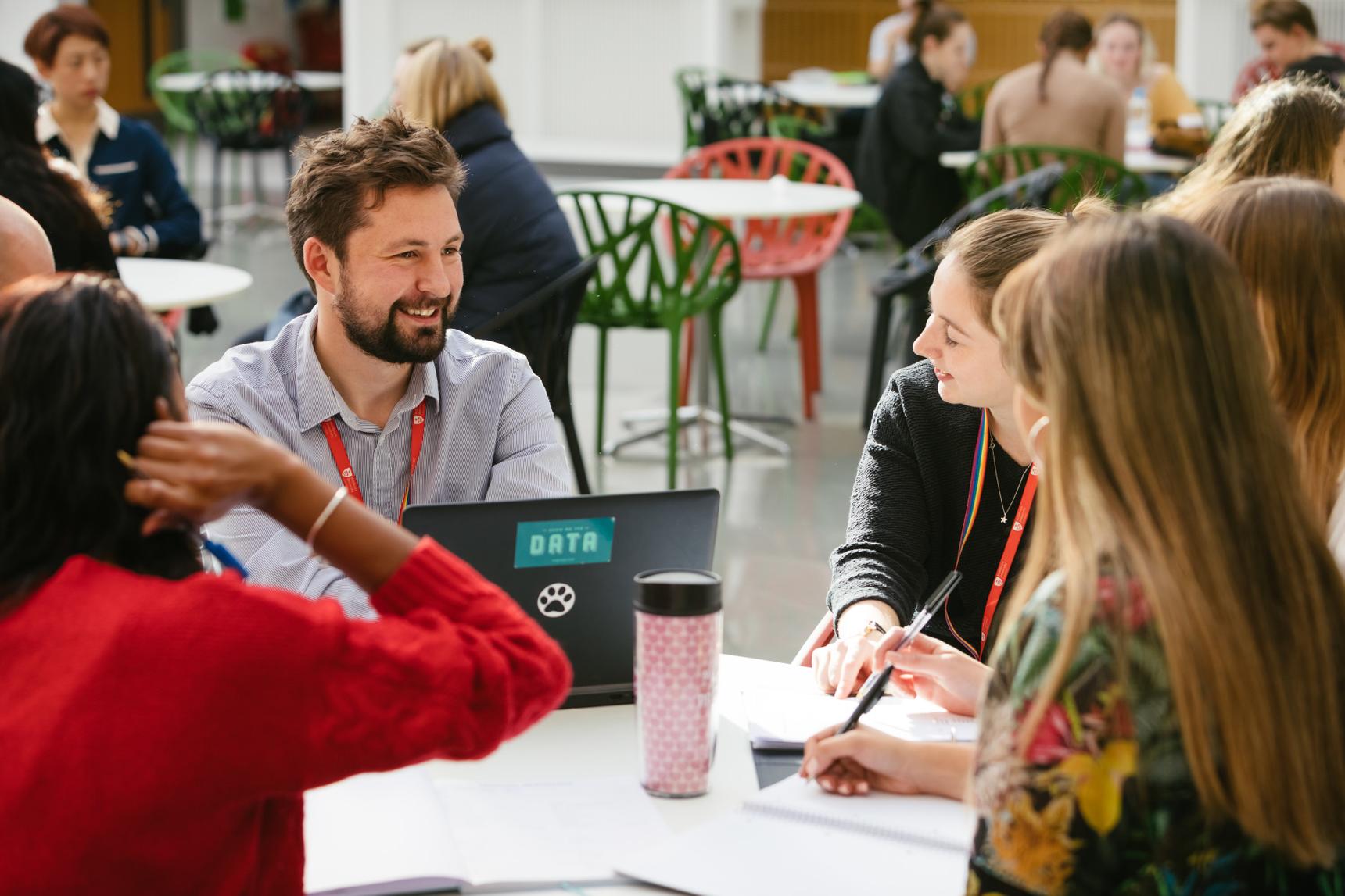 A diverse group of individuals sitting around a table, engrossed in a conversation.