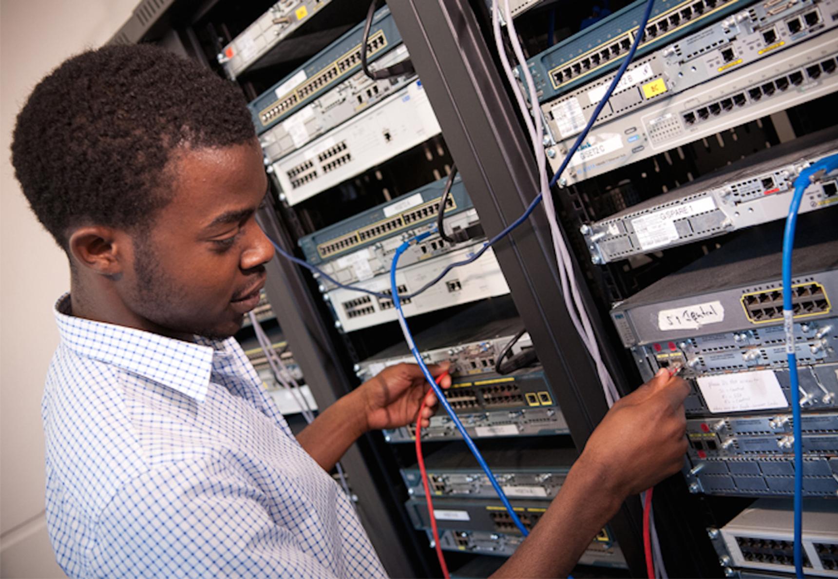 A man plugging a cable into a device