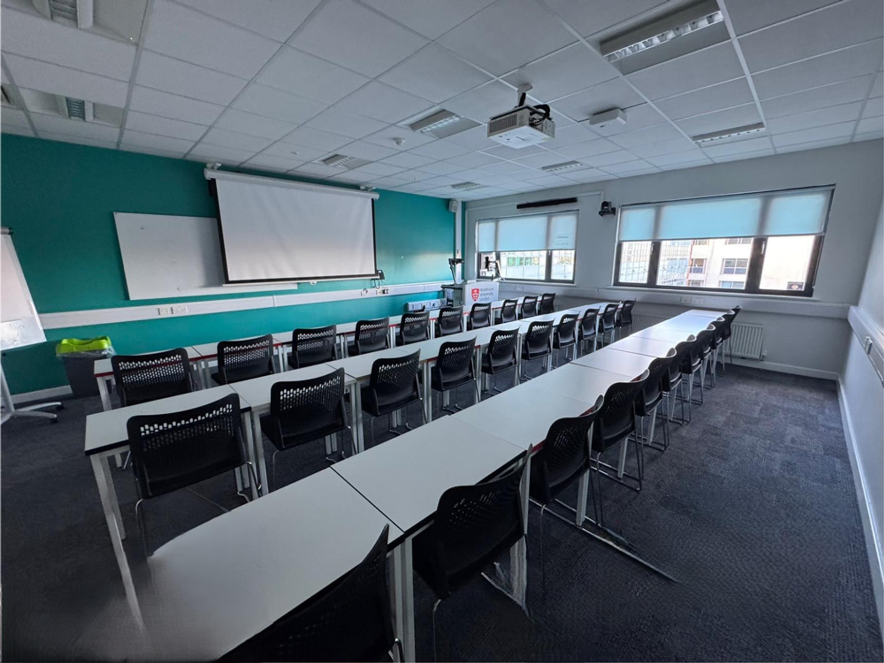 An empty classroom with a whiteboard on the wall
