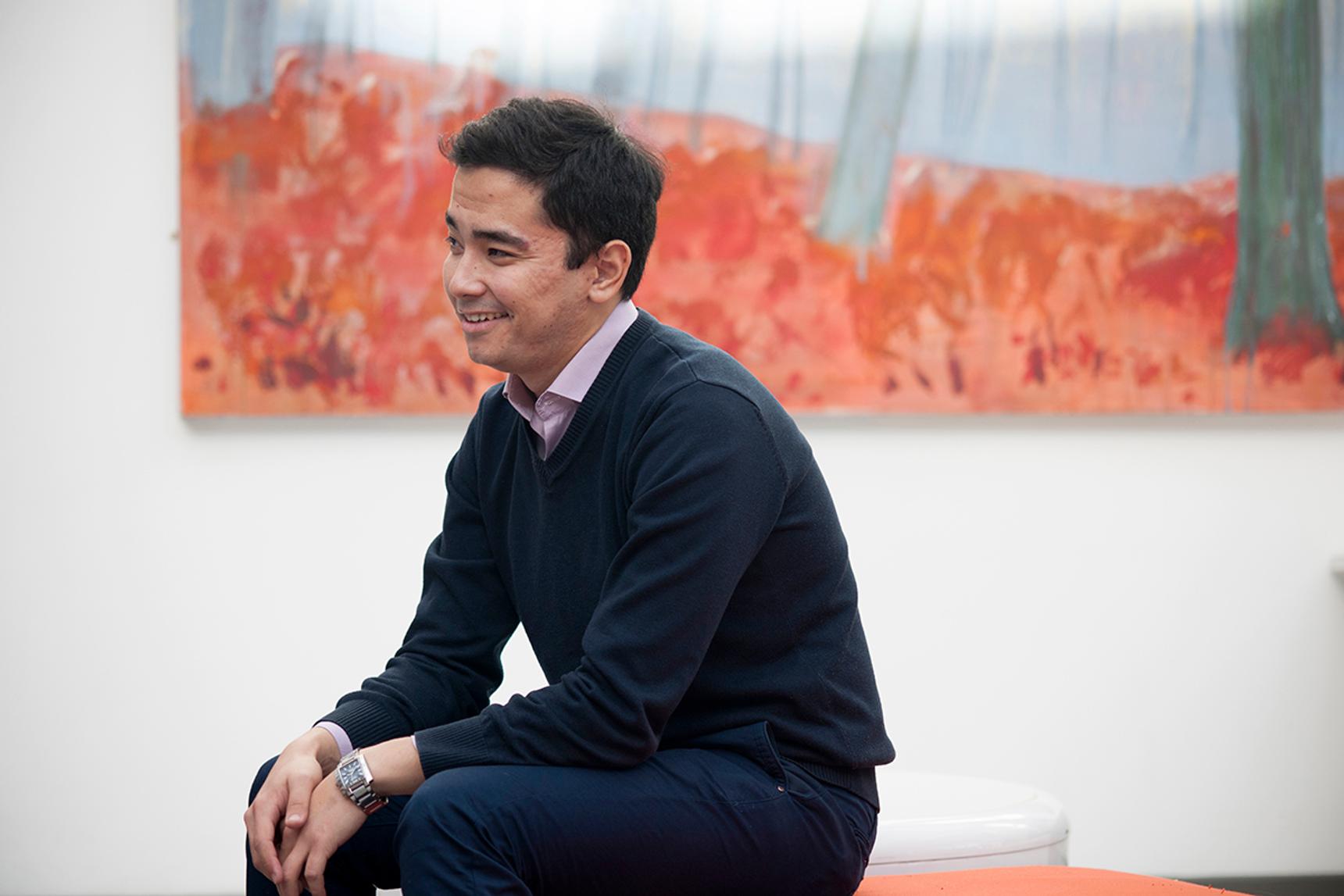 portrait of student wearing smart casual clothing in front of abstract painting