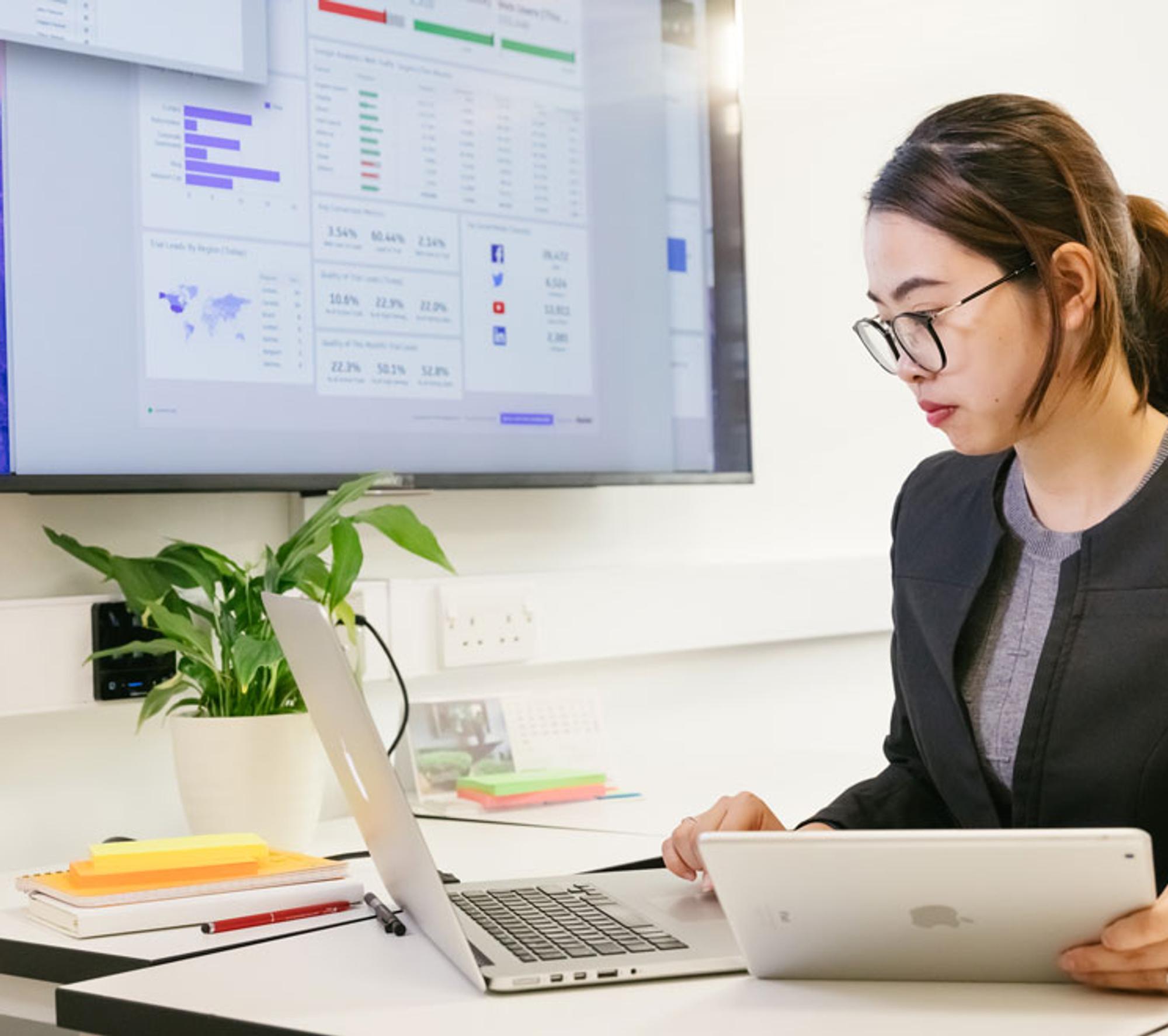 Postgraduate student sat at desk using laptop