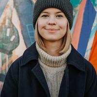 Person wearing hat in front of painted wall