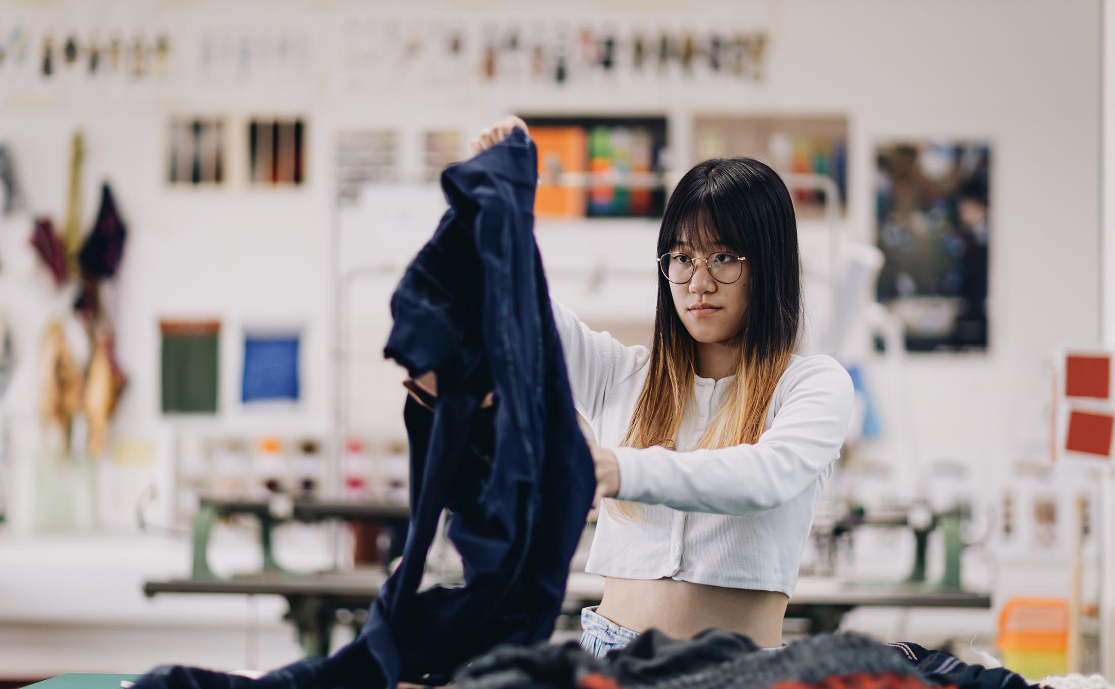 Fashion student looking at garments in studio