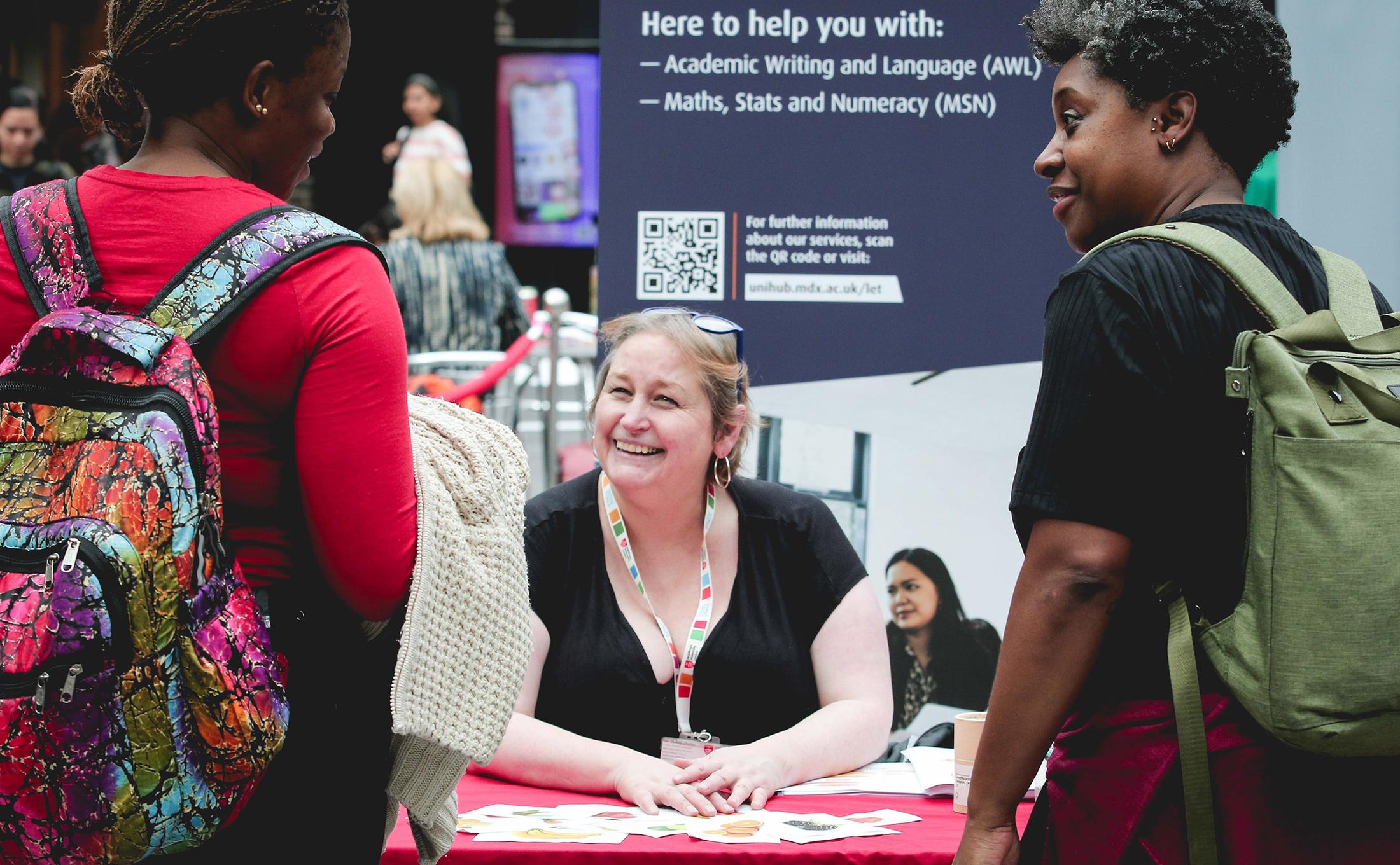 Two festival attendees speak to MDX student support representative