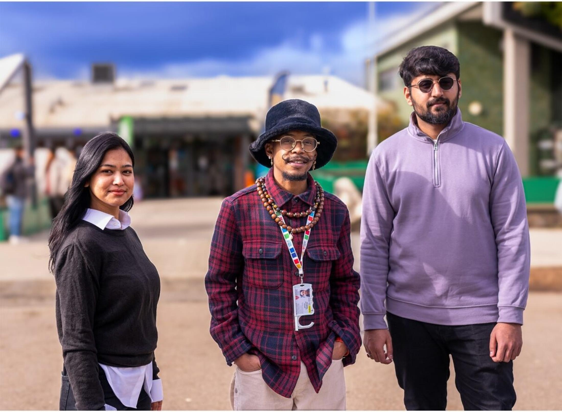 Three students smiling for a photoshoot