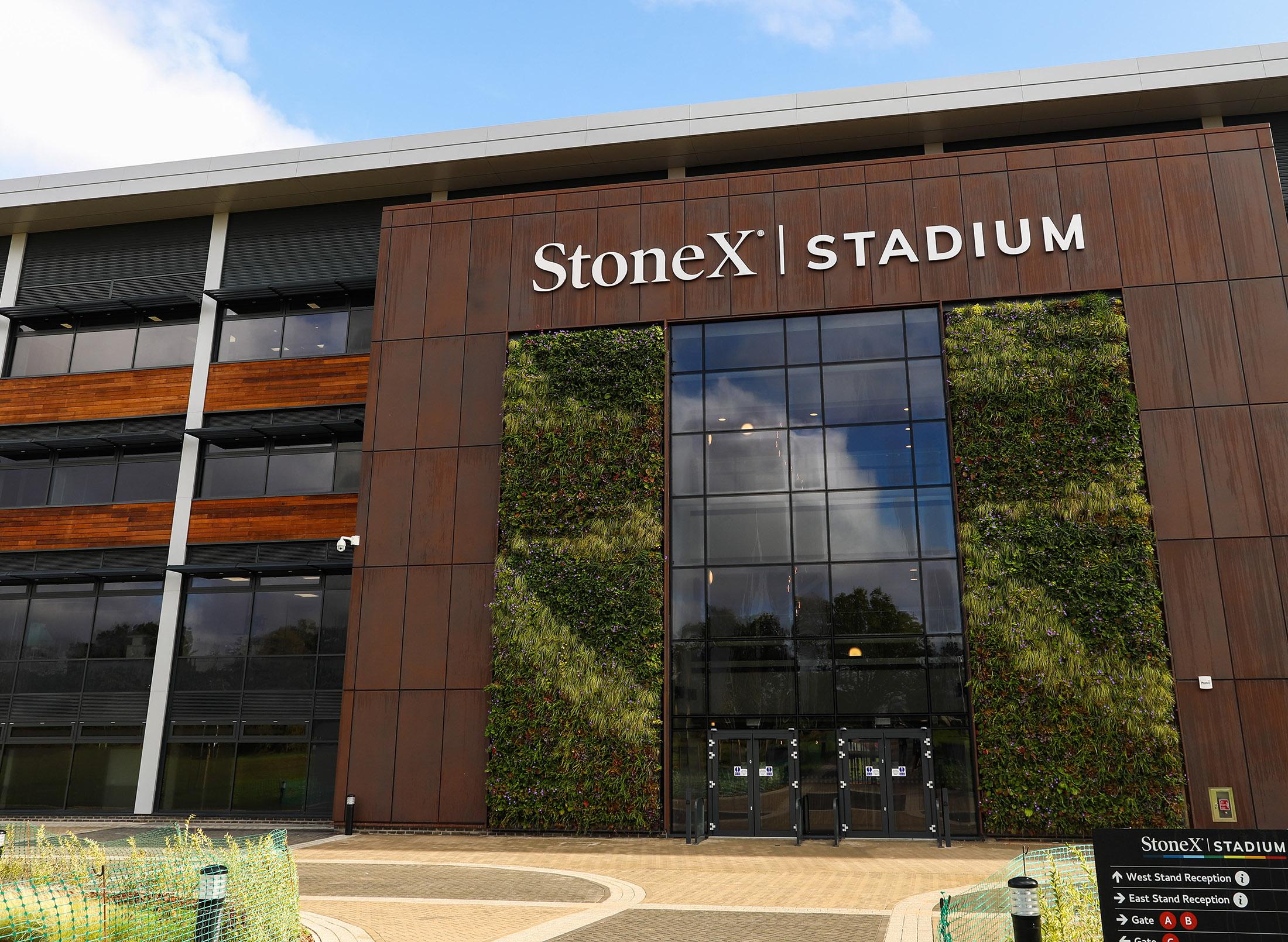 outside of a large stadium with climbing plants, large letters on stadium say StoneX Stadium