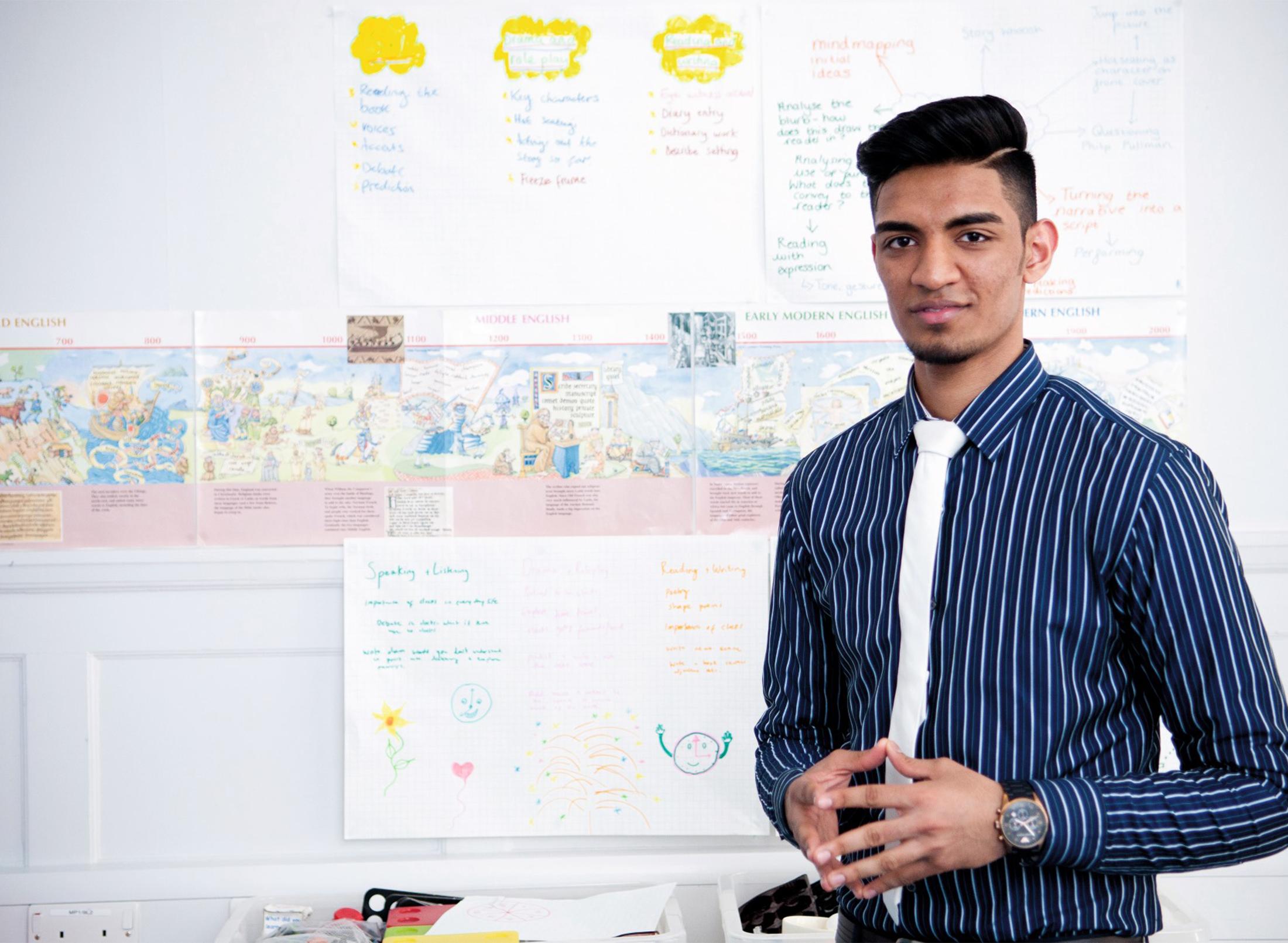 A teacher standing in front of a display of work