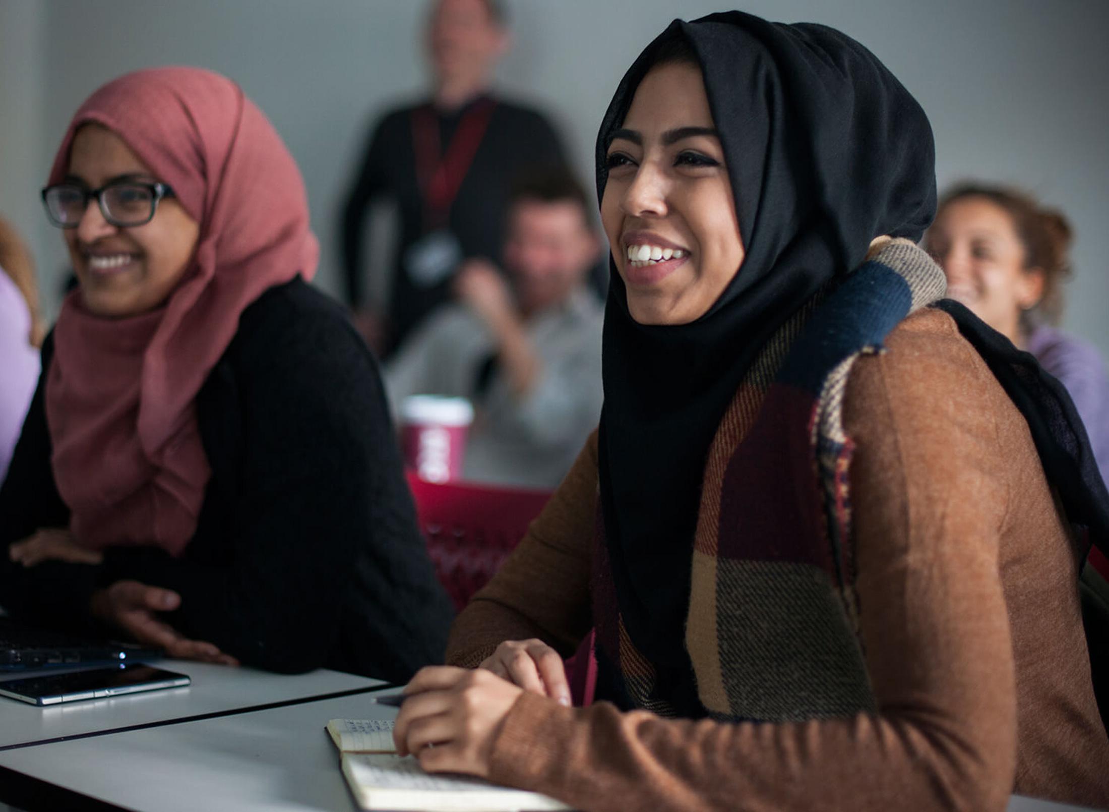 Female students wearing hijabs attending an education studies class