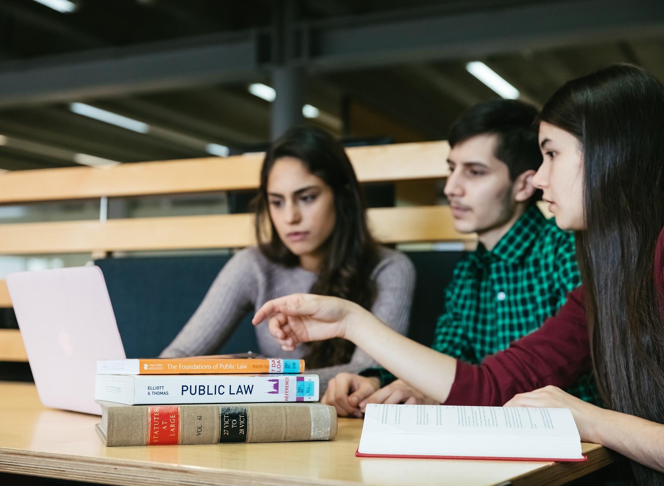 Students studying law with a laptop on the desk.