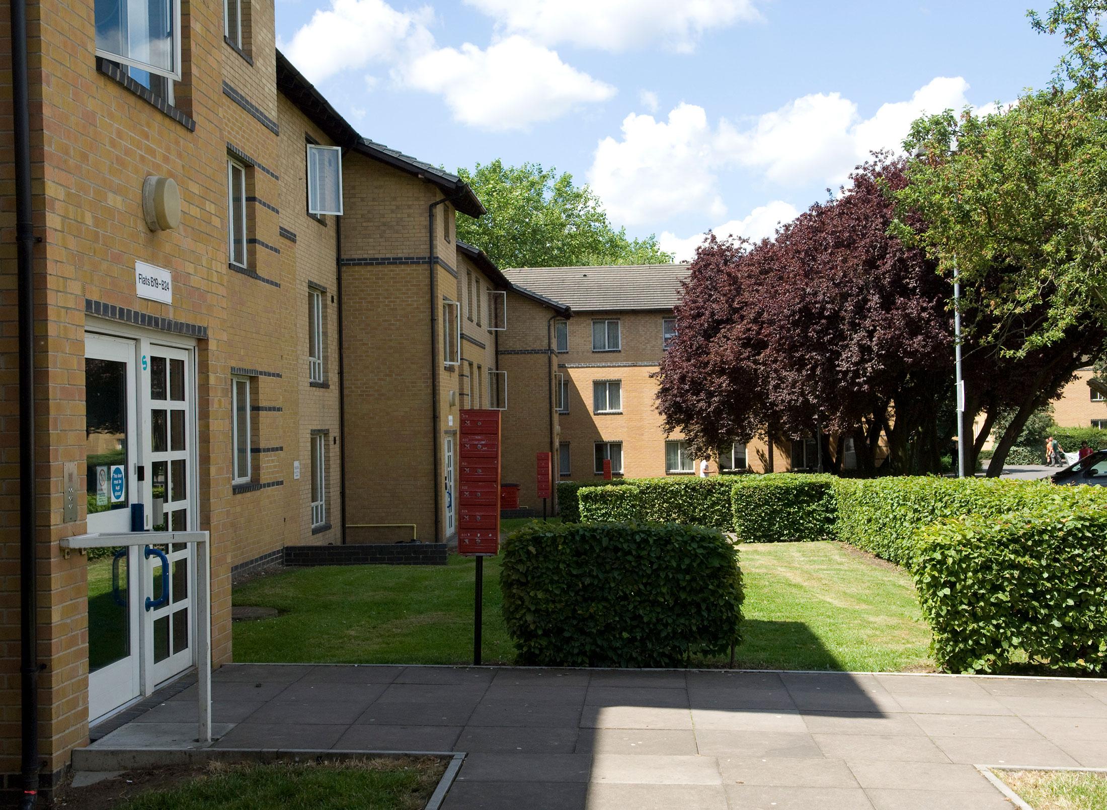 Exterior of Platt Hall showing entrance and gardens partially in the shade